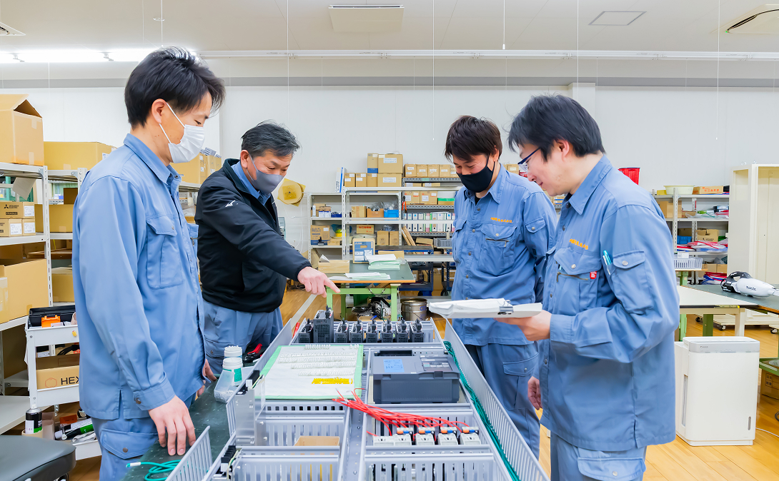 社員同士で操作盤製作について意見交換している様子